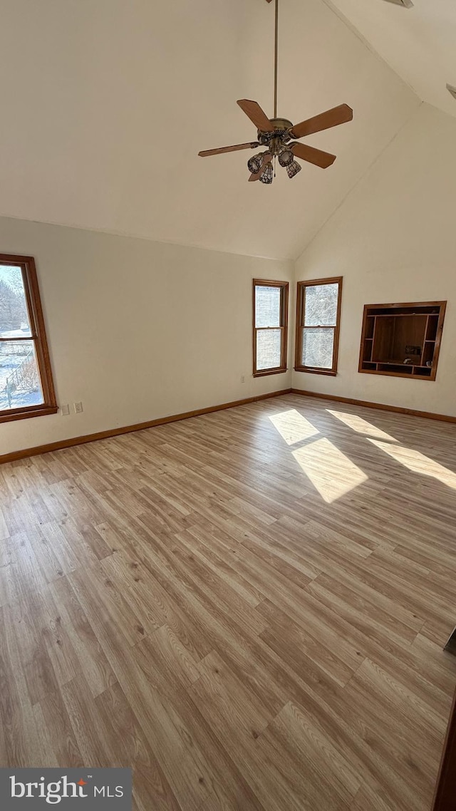 unfurnished room with ceiling fan, light wood-type flooring, and vaulted ceiling