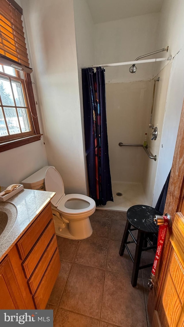 bathroom with curtained shower, toilet, vanity, and tile patterned floors