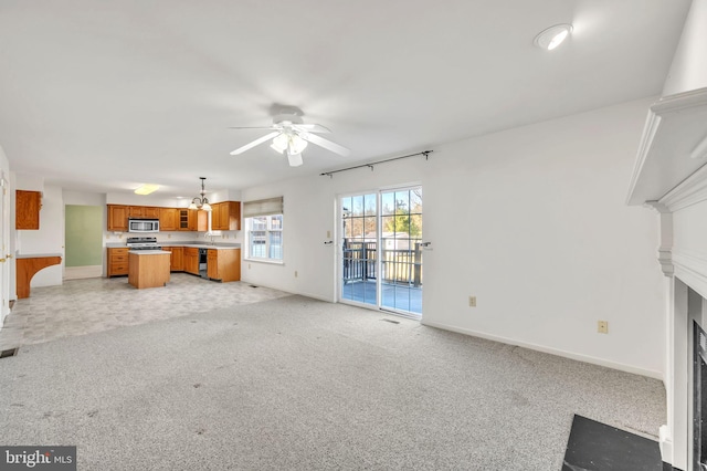 unfurnished living room with light colored carpet and ceiling fan