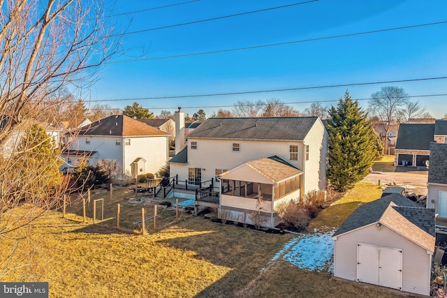 back of house with a shed, a yard, and a deck