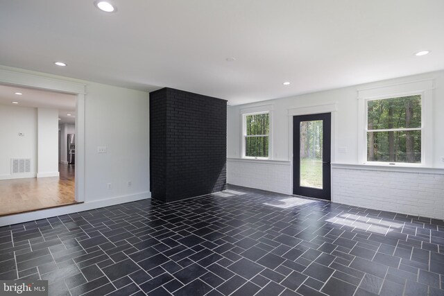 unfurnished room with brick wall