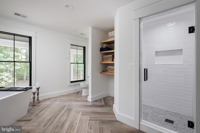 interior space featuring toilet, separate shower and tub, and parquet flooring