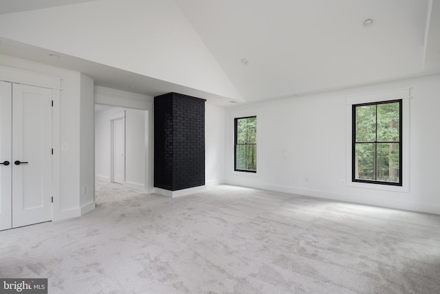 carpeted empty room featuring a wealth of natural light and high vaulted ceiling