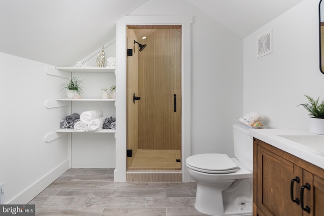 bathroom with walk in shower, vanity, lofted ceiling, and toilet