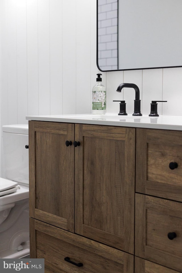 bathroom with backsplash, sink, and toilet