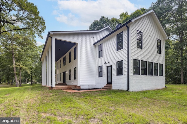 rear view of property with a lawn