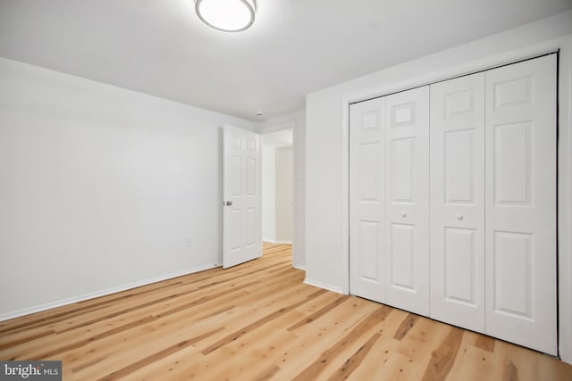 unfurnished bedroom with wood-type flooring and a closet