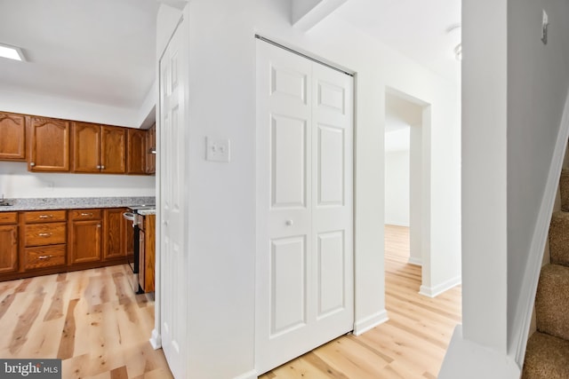 kitchen with range and light hardwood / wood-style flooring