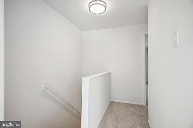 hallway featuring light colored carpet