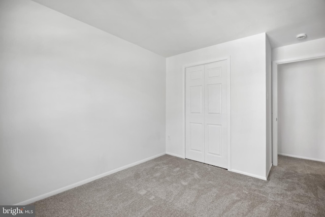 unfurnished bedroom featuring carpet flooring and a closet