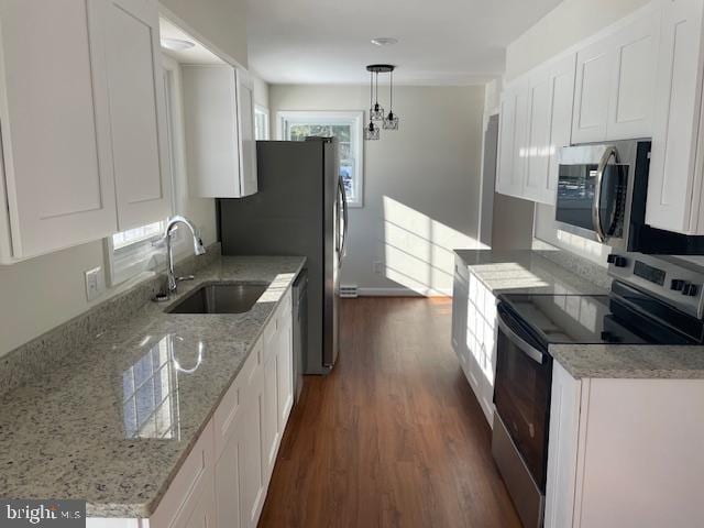 kitchen with white cabinetry, sink, stainless steel appliances, and hanging light fixtures