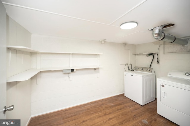 laundry area with dark hardwood / wood-style flooring and washer and dryer