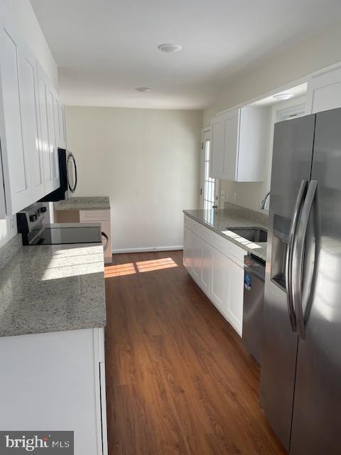 kitchen featuring sink, dark wood-type flooring, stainless steel appliances, and white cabinets