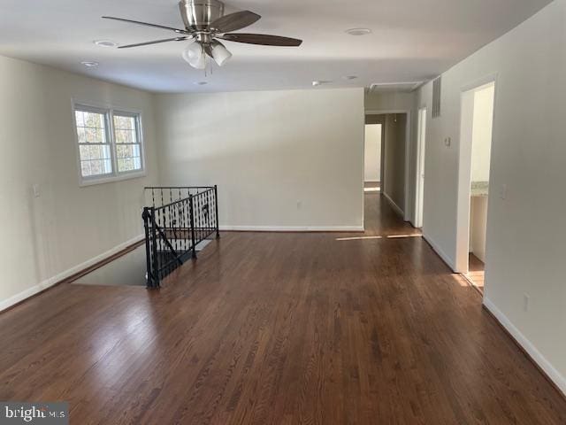 unfurnished room featuring dark wood-type flooring and ceiling fan