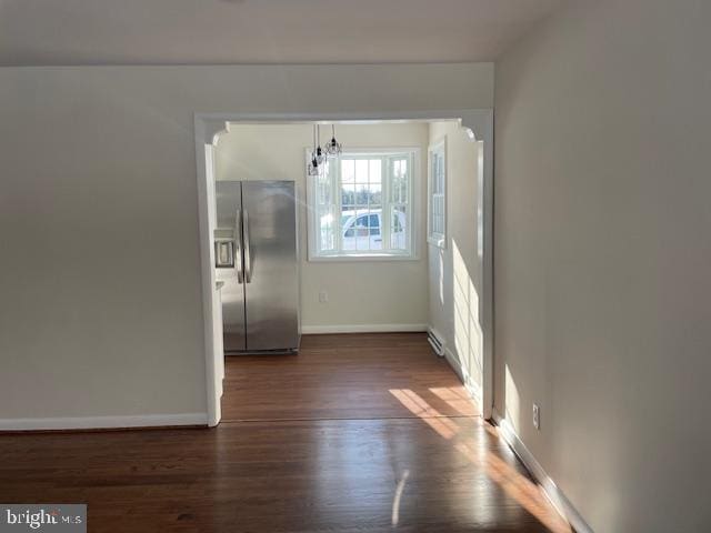 hall featuring a baseboard heating unit and dark hardwood / wood-style floors