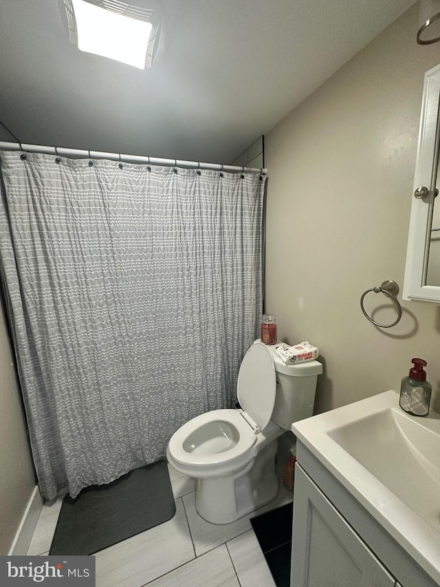 bathroom featuring tile patterned flooring, vanity, and toilet