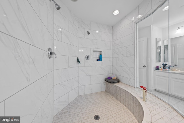 bathroom featuring tiled shower and vanity