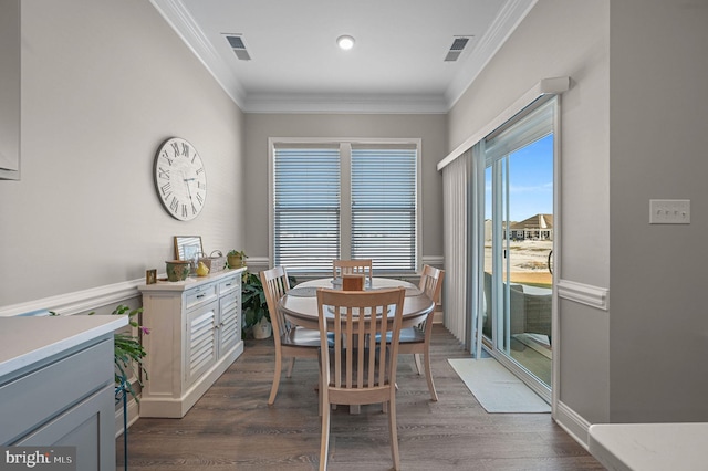 dining space with dark wood-type flooring and ornamental molding