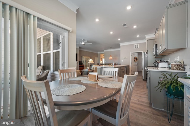 dining room featuring ceiling fan, ornamental molding, and hardwood / wood-style flooring