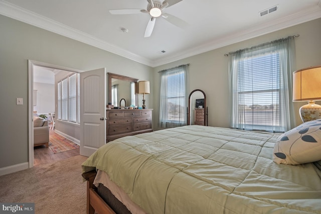 carpeted bedroom with ceiling fan and crown molding