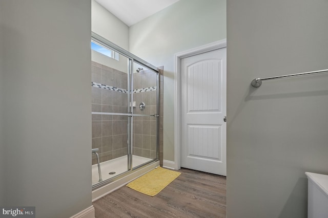 bathroom featuring an enclosed shower and wood-type flooring