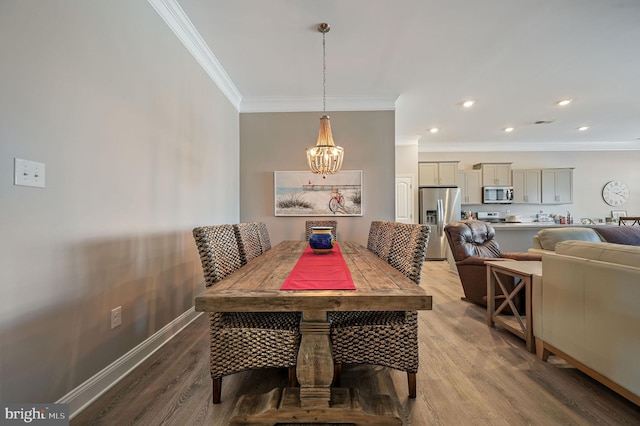 dining space featuring a chandelier, ornamental molding, and hardwood / wood-style flooring