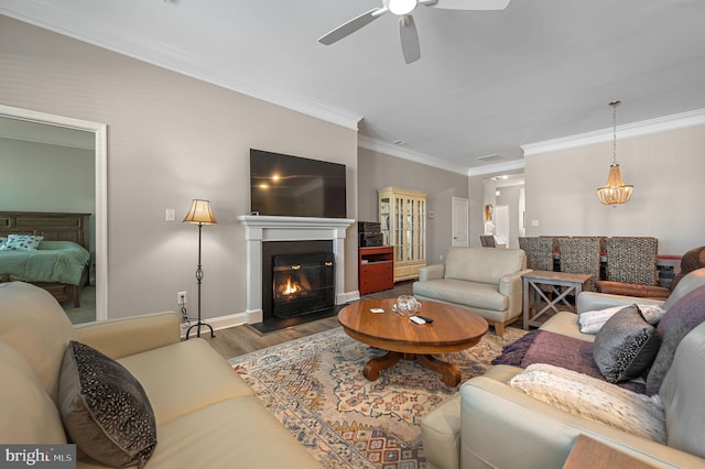 living room featuring ceiling fan, dark hardwood / wood-style flooring, and crown molding