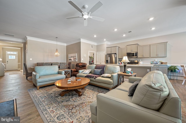 living room with light wood-type flooring, ceiling fan, and ornamental molding