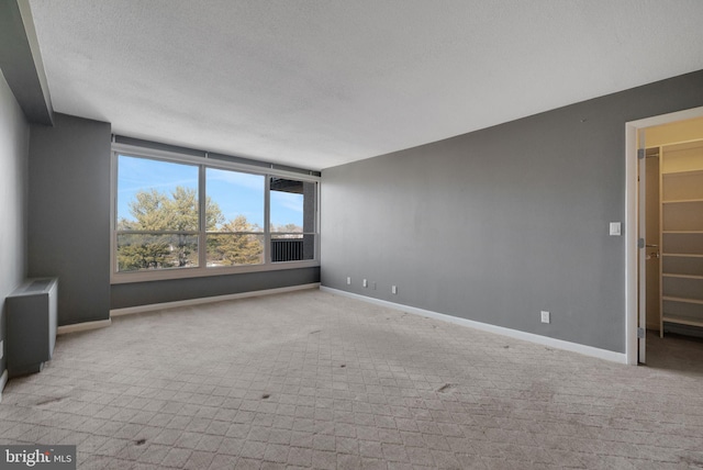 carpeted empty room with a textured ceiling