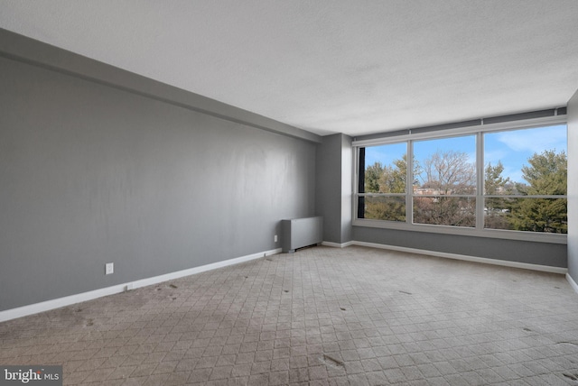 empty room with radiator heating unit and a textured ceiling