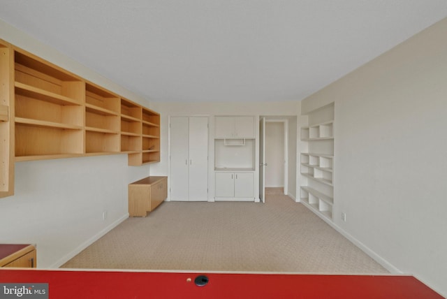 carpeted spare room with built in shelves