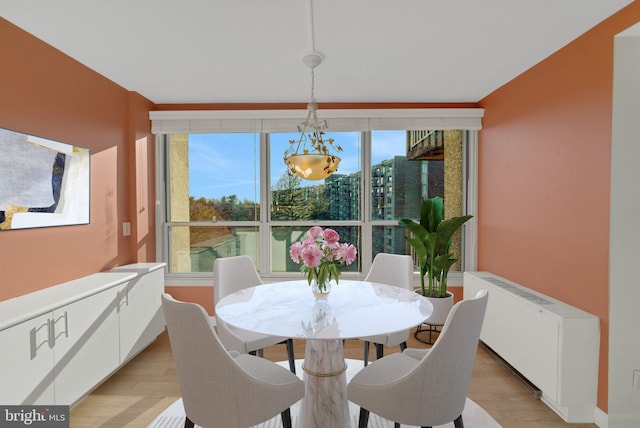 dining room featuring radiator heating unit and light hardwood / wood-style floors