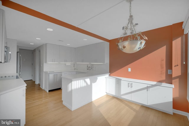 kitchen featuring decorative light fixtures, light wood-type flooring, decorative backsplash, and white cabinets