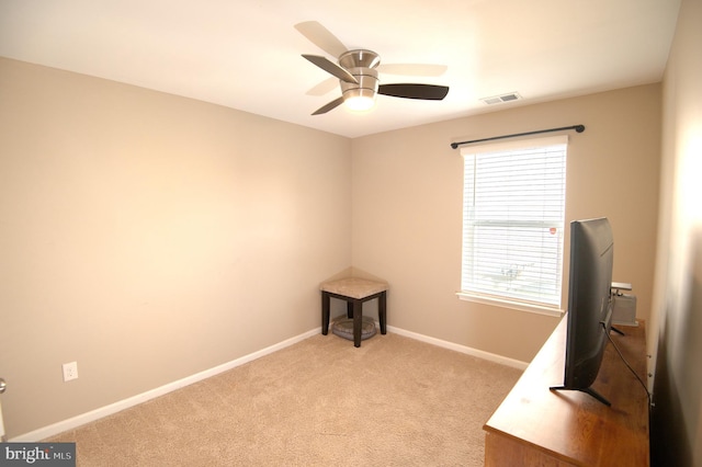 unfurnished office featuring light carpet and ceiling fan