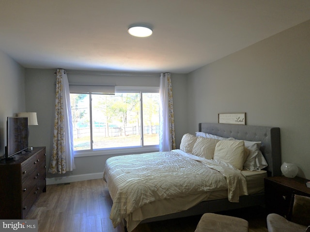 bedroom featuring baseboards and light wood finished floors