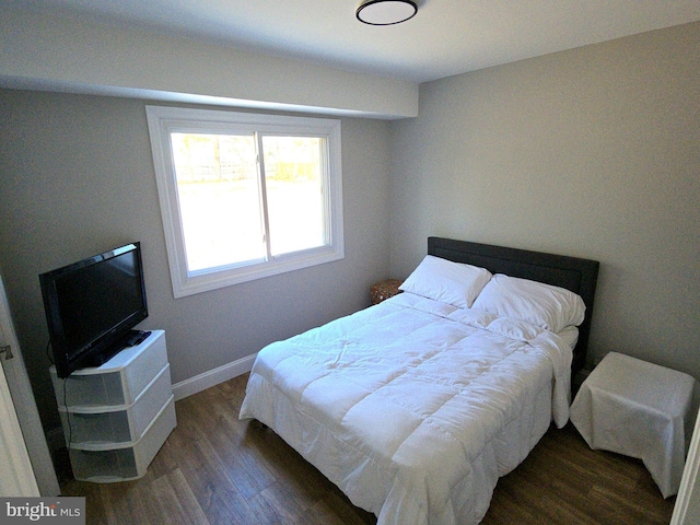 bedroom with baseboards and wood finished floors