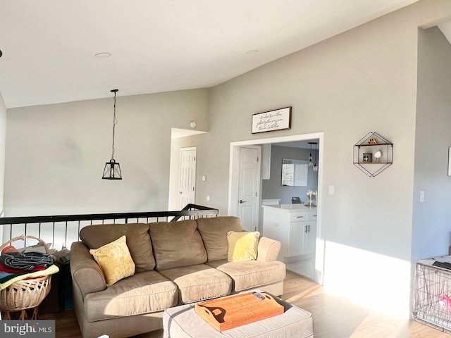 living area with high vaulted ceiling and light wood finished floors