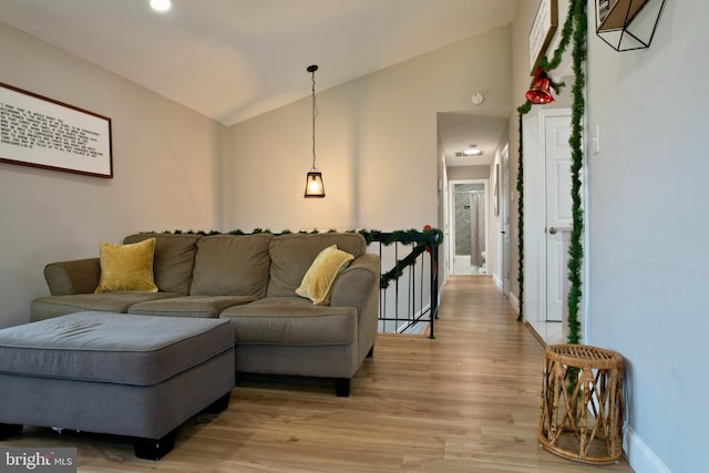 living area with lofted ceiling, light wood-style floors, and baseboards