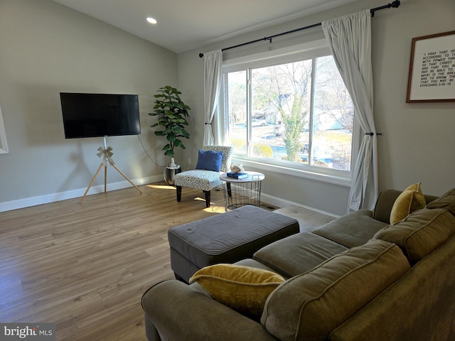 living area with recessed lighting, baseboards, wood finished floors, and vaulted ceiling