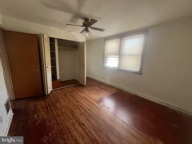 unfurnished bedroom with dark hardwood / wood-style flooring, ceiling fan, and a closet