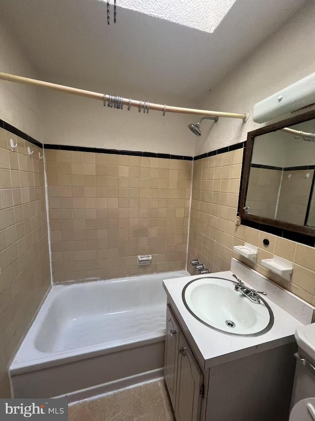 full bathroom featuring tile patterned flooring, vanity, toilet, and tiled shower / bath