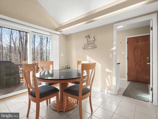 tiled dining room with lofted ceiling