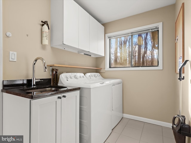 clothes washing area featuring cabinets, washing machine and dryer, sink, and light tile patterned floors