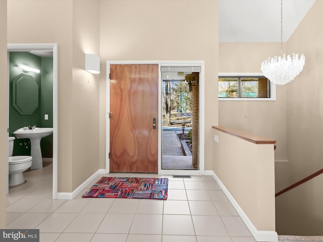 entryway featuring an inviting chandelier, light tile patterned floors, and sink