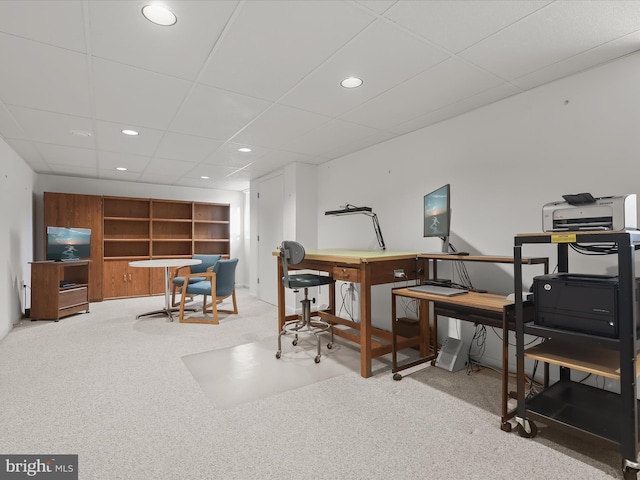 carpeted home office with a paneled ceiling