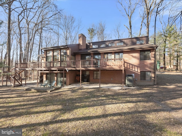 back of property with central AC unit, a yard, a deck, and a patio area