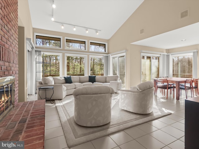 tiled living room featuring a fireplace and high vaulted ceiling