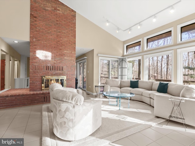 tiled living room with high vaulted ceiling, a wealth of natural light, and a fireplace