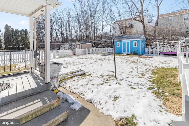 yard covered in snow featuring a storage shed