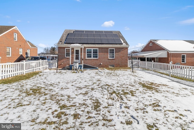 snow covered back of property with solar panels